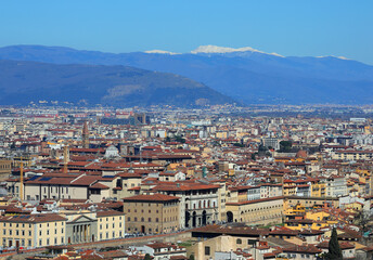 Aerial view of the houses and buildings of a crowded city with mountains in the background ideal as a concept of population explosion