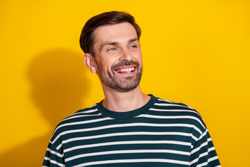 Smiling Mature Man in Striped T-Shirt Posing Against Vibrant Yellow Background, Radiating...