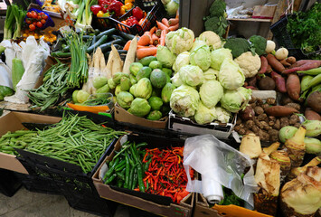 stall of fruit and vegetables for sale with legumes cabbages and chili peppers from south america