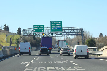 Obraz premium sign on an italian highway showing italian city names with cars and vans