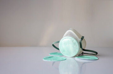 Respirator Mask with Green Filters on White Surface for Clean Air Protection