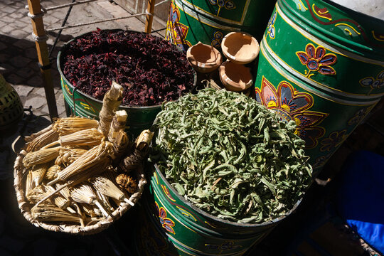 Moroccan market with herbal products. Spices and dried herbs displayed on the street. Decorative barrels filled with natural remedies. Green and healthy ingredients for cooking and wellness.