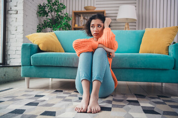 Obraz premium Young woman in a modern living room wearing casual attire expresses emotions, sitting on a rug during daylight with a cozy interior design