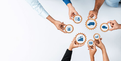 This image showcases diverse hands working collaboratively over gears, representing various business tools like marketing and analytics in a professional setting. Amity