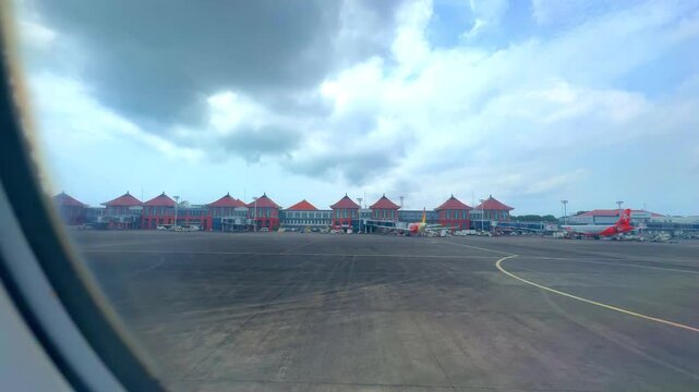 Bali airport viewed from airplane window showing buildings planes tarmac Bali Indonesia