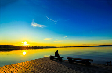 Sunrise on the lake. Man silhouette on lake at dawn