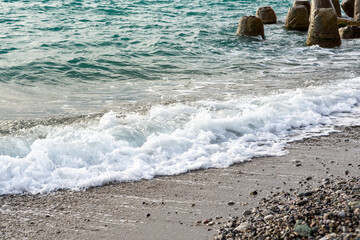 Splash of sea waves crashing on a pebble beach. Warm summer evening on the Black Sea coast