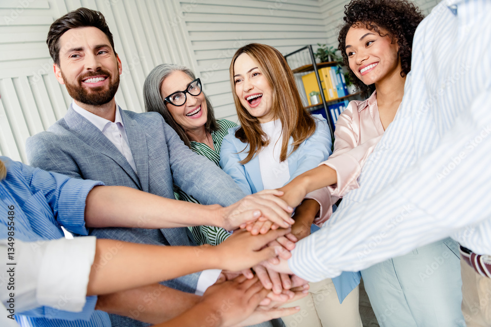Poster diverse work colleagues joining hands symbolizing teamwork and collaboration in an office setting