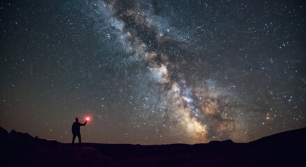 Fototapeta premium Person holding light under starry sky with Milky Way