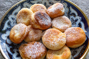 Homemade golden fried dough pastries with powdered sugar