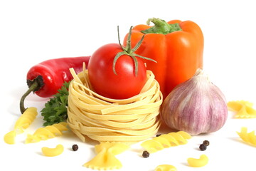 Fresh ripe harvest of vegetables lies on white isolated background with dry pasta before cooking.	