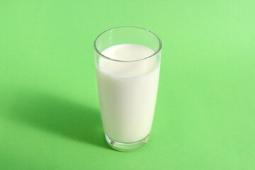 There is a glass of milk on a green background.