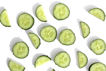 Fresh cucumber sliced ​​into rings and half rings lies on a white background, texture.