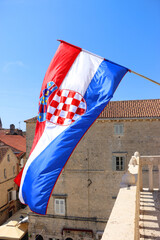 Croatian flag blowing in the wind on the bell tower of The Cathedral of St. Lawrence, landmark in...
