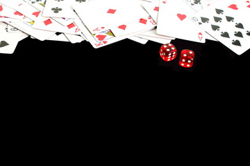 Playing cards lie with red dice on a black background.