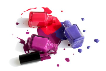 Three types of nail polish with spilled liquid stand on a white background.