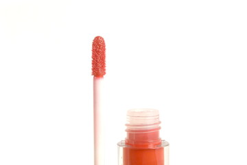 On a white background there is a pink lip gloss in a tube.	