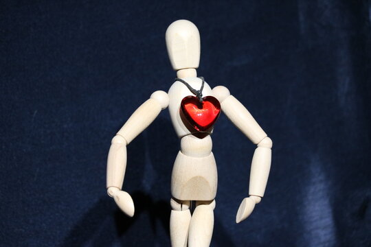 Figure of a wooden toy man with a precious stone in the form of a red heart