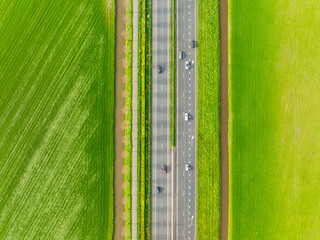 Drone view of a road in the middle of a field. Landscape from a drone. Road and transport. Car...