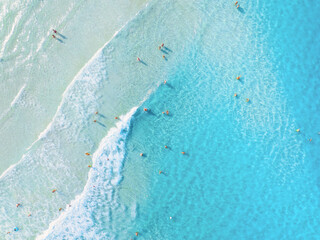 Aerial view on beach and people. Vacation and adventure. Top view from drone at beach and azure...