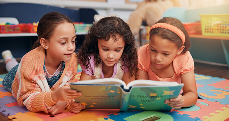 Girls, reading book and group on carpet, school and learning with education, children and bonding together. Friends, storytelling and kids in classroom, literacy knowledge and happiness with fantasy