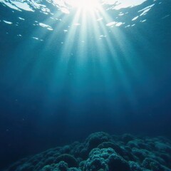 Obraz premium Submerged perspective of dark blue ocean surface with gentle waves and sunlight filtering down from above, calm, serenity