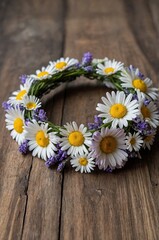 Obraz premium Floral crown made with daisies and lavender on rustic wooden surface for celebration or decoration