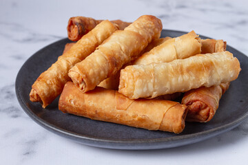fried spring rolls with cheese, on a plate, with cream sauce, no people,