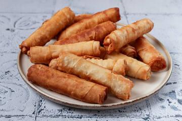 fried spring rolls with cheese, on a plate, with cream sauce, no people,