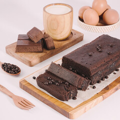Chocolate brownies made from eggs and fresh milk sprinkled with chocolate chips on a wooden tray