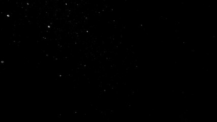 Freeze motion of dust particles flying , isolated on black background