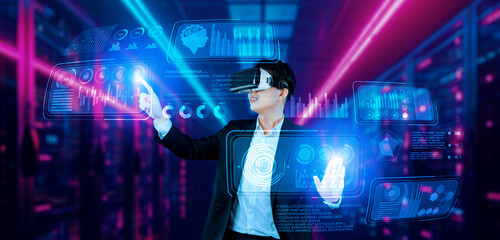 Businessman with headset standing at data center while analyzing financial data. Manager pointing marketing statistic hologram and using augmented reality goggles while making a decision. Ingenuity.