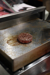 hamburguesa de carne friéndose  a la plancha