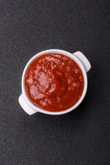 Red sauce or ketchup with salt and spices in ceramic sauce boat