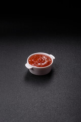 Red sauce or ketchup with salt and spices in ceramic sauce boat