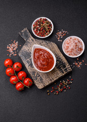 Red sauce or ketchup with salt and spices in ceramic sauce boat