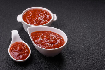 Red sauce or ketchup with salt and spices in ceramic sauce boat