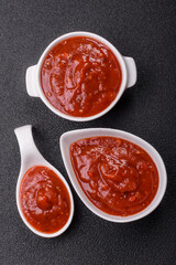 Red sauce or ketchup with salt and spices in ceramic sauce boat