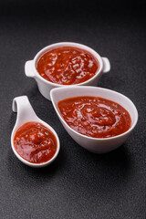 Red sauce or ketchup with salt and spices in ceramic sauce boat