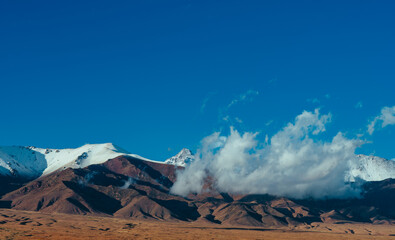 Beautiful high mountains with snow and clouds landscape in Kyrgyzstan