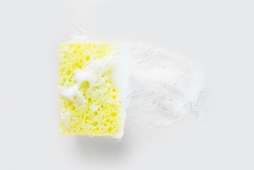 yellow sponge for washing dishes with foam on white
