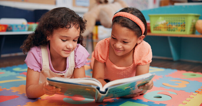 Girls, reading book and friends on ground, school and relax with education, break and bonding together. Learning, storytelling and children in classroom, literacy knowledge and happiness with kids