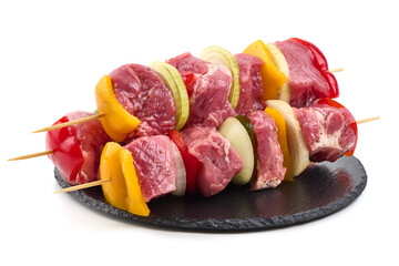 Raw Pork Skewers with Vegetables on Black Slate, Isolated on White Background.