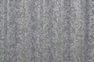 A grey metal surface with a pattern of small squares