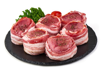 Raw bacon-wrapped beef medallions with seasoning, isolated on white background.