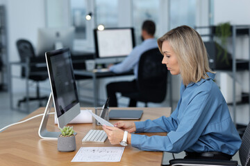 Technician making digital engineering drawing on computer at desk in office