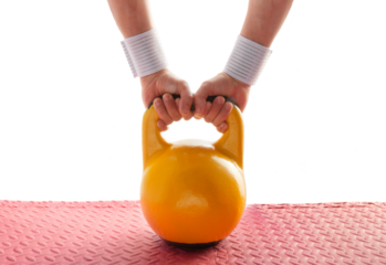 Hands holding kettlebell, preparing to perform exercises. Kettlebell for fitness and strength training on the floor in the gym. Endurance and competition. Healthy lifestyle concept. Close-up, cut out