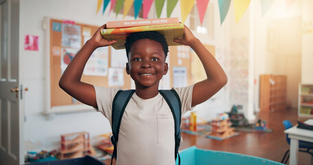 Boy, portrait and books on head at school, smile and excited for education, story or development....