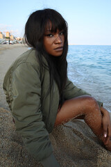 Attractive beautiful and young African American woman posing outdoor wearing bomber jacket....