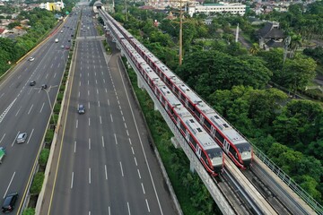 Aerial view of an LRT train parked adjacent to the toll road